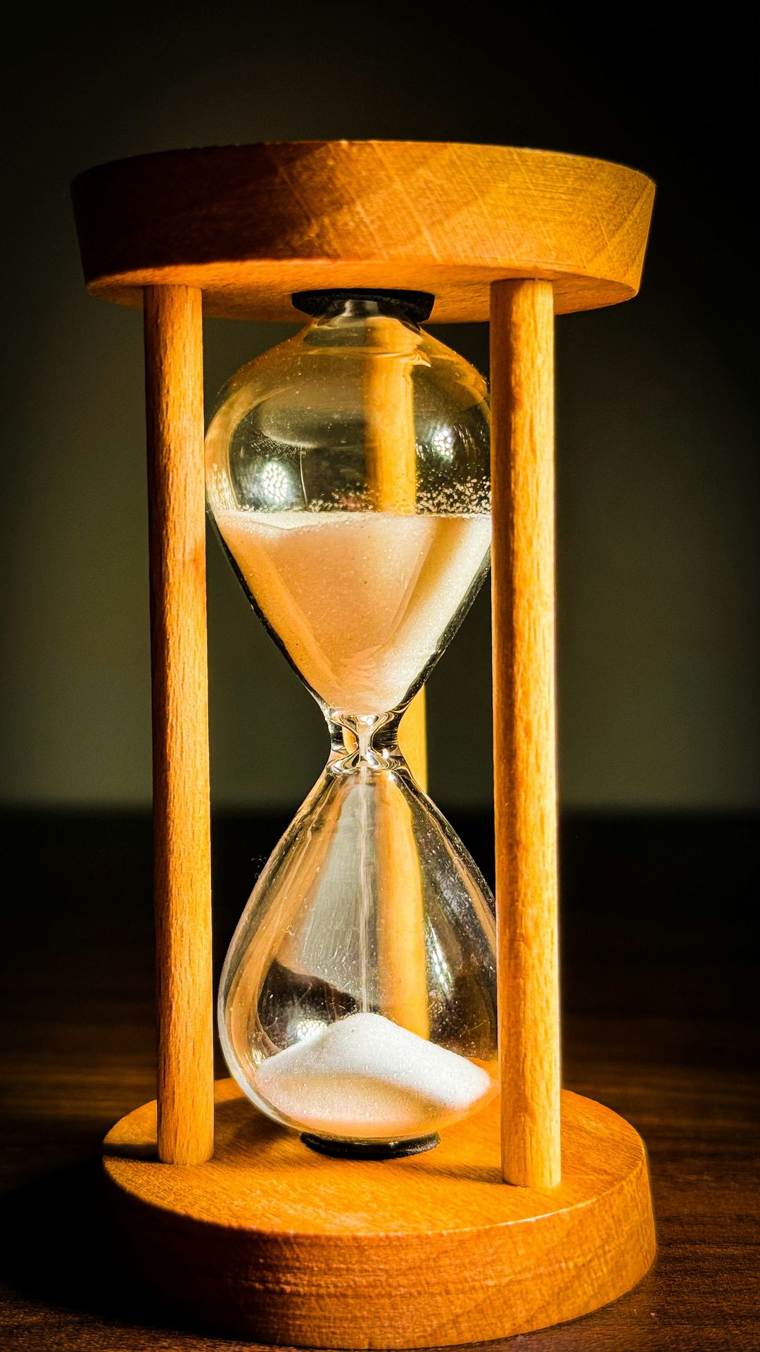 An hourglass sitting on top of a wooden table